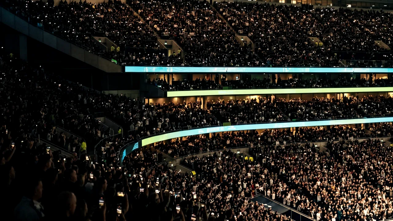 A full arena bowl at night, thousands of fans in the stands