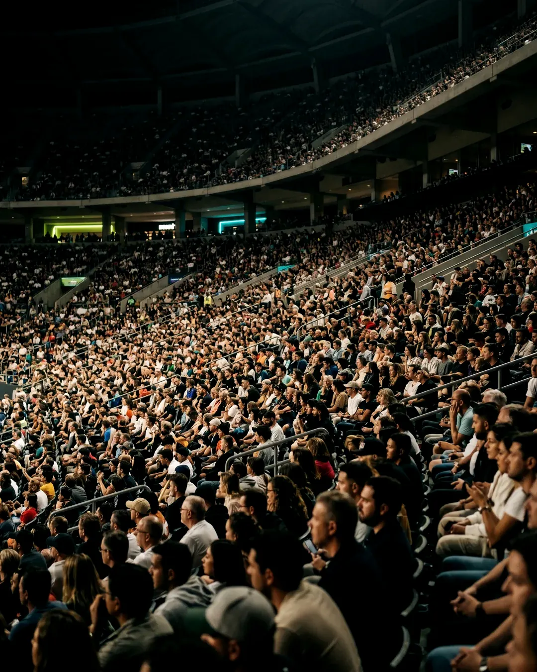 A packed crowd filling an iconic arena at night