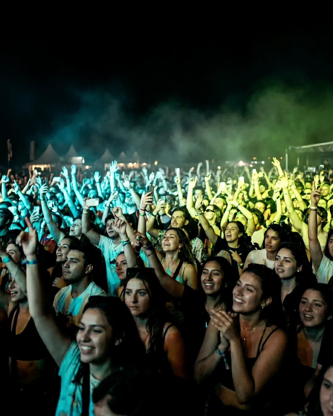 A festival crowd under stage light at night